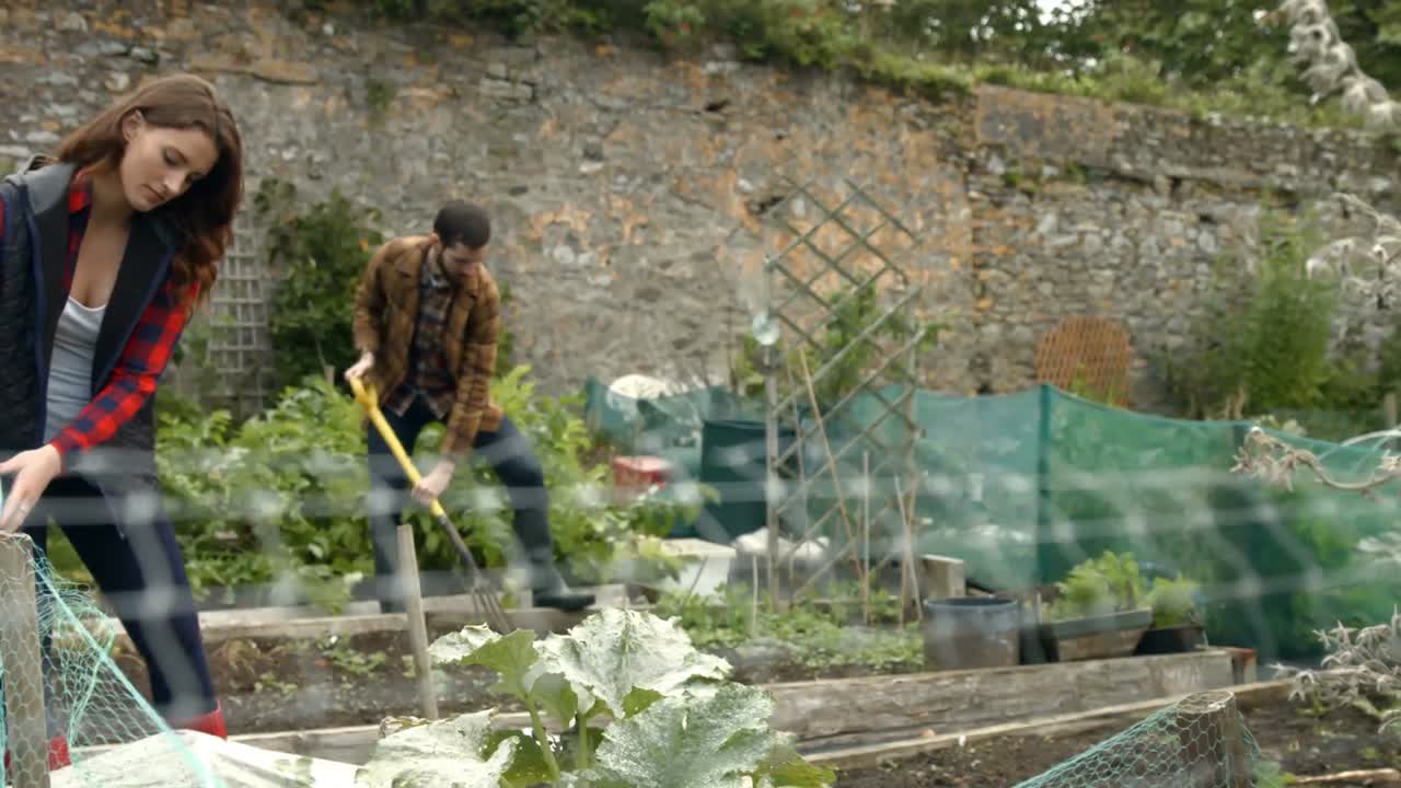 una pareja joven haciendo jardinería.