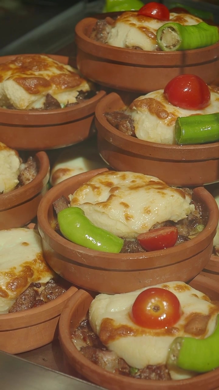 Piatti tradizionali turchi al forno serviti in tegami di terracotta.