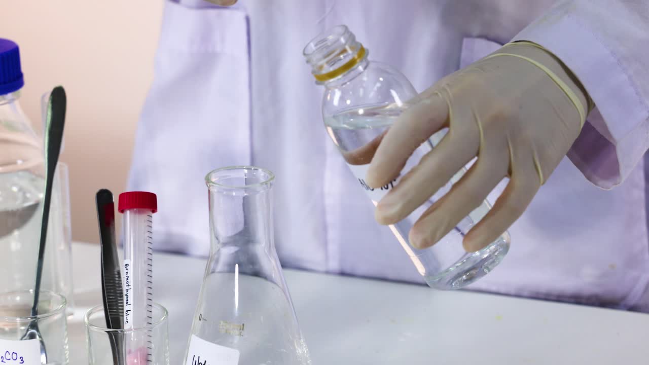 Scientist pouring water into a flask