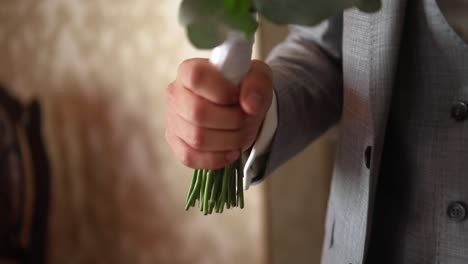 wedding bouquet in the hands of the groom