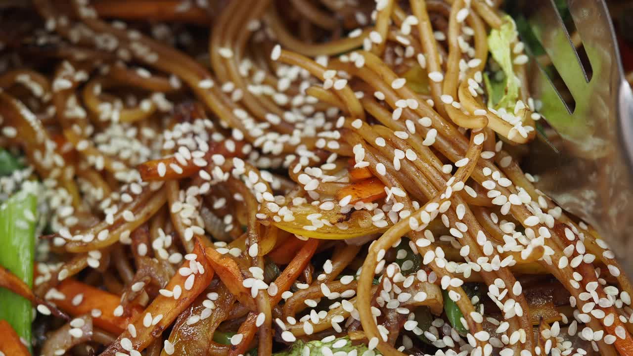 Close-up of Stir-Fried Noodles with Sesame Seeds and Vegetables
