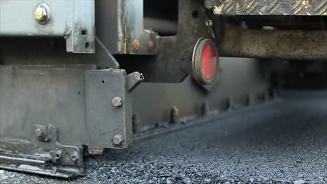 vista de cerca del proceso de construcción de carreteras de difusión, difusión o colocación de materiales de mezcla de asfalto utilizando una máquina de difusión de acabado de asfalto