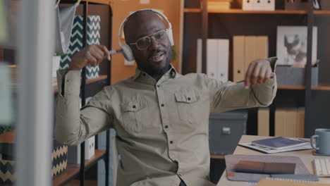 happy businessman enjoying music in office