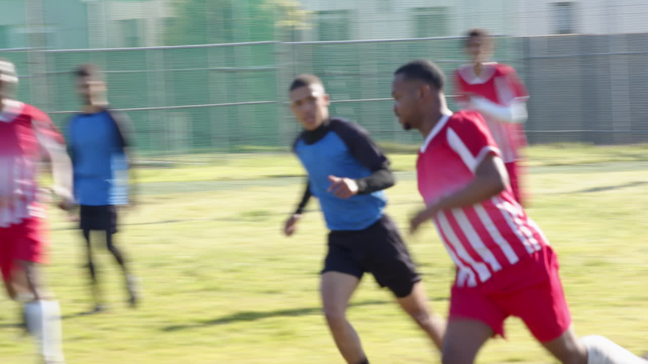 Playing soccer, players aiming to score goal while goalkeeper defending net