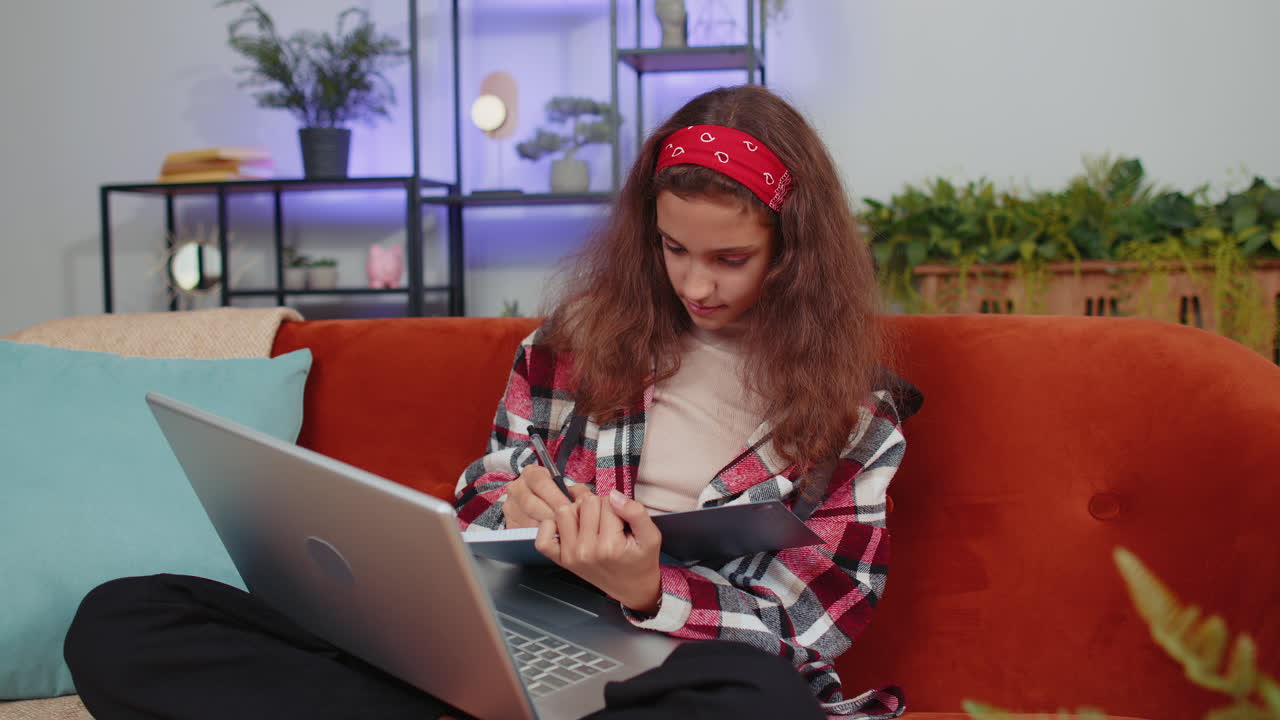niña estudiante estudiando en casa en una computadora portátil haciendo videoconferencia hablando con una cámara web