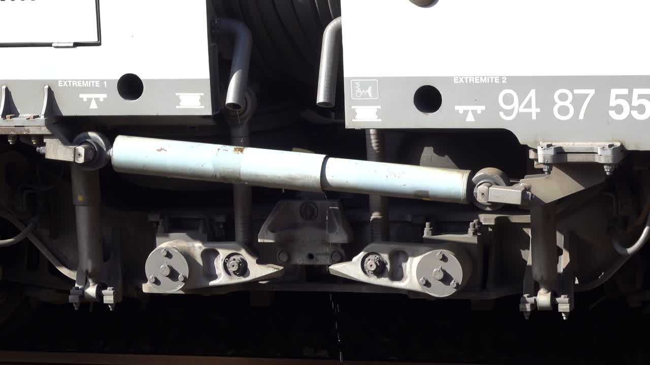 Vallauris, France - July 6, 2025: Close up of a train's undercarriage suspension system, with droplets of water falling from the hydraulic components