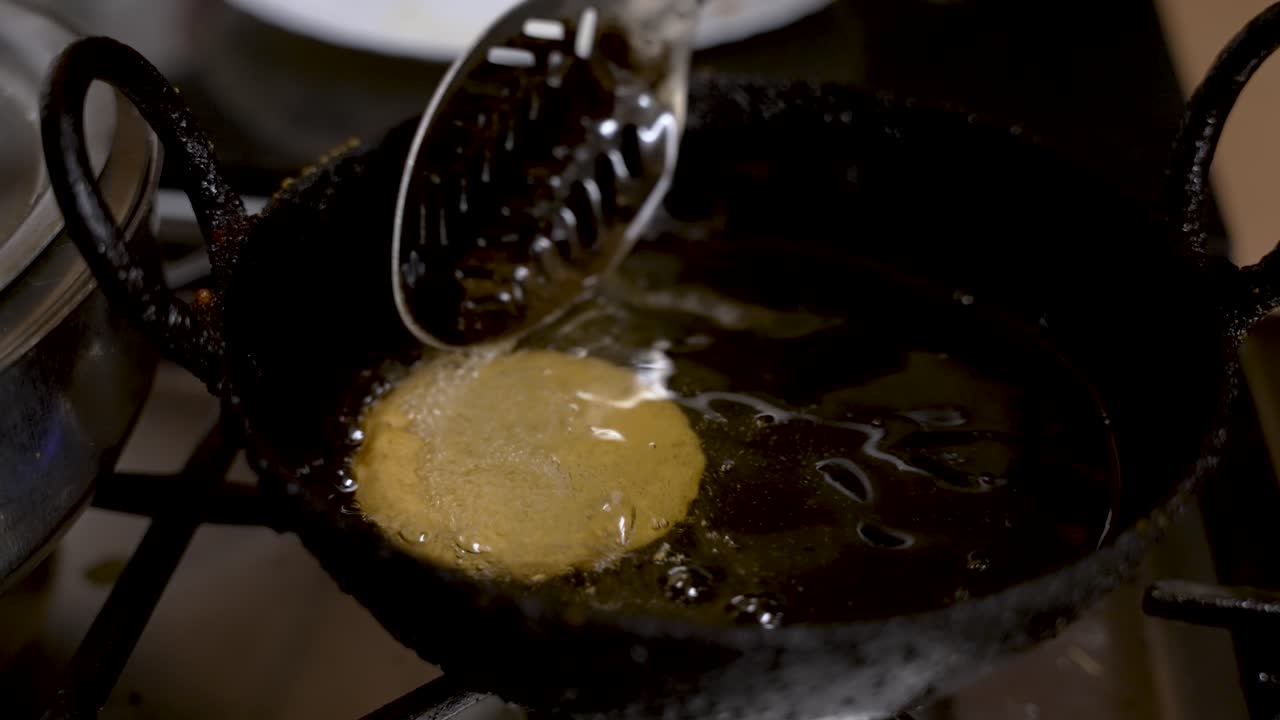 View Of Metal Slotted Spoon Gently Moving Floating Fresh Guror Handesh In Hot Oil