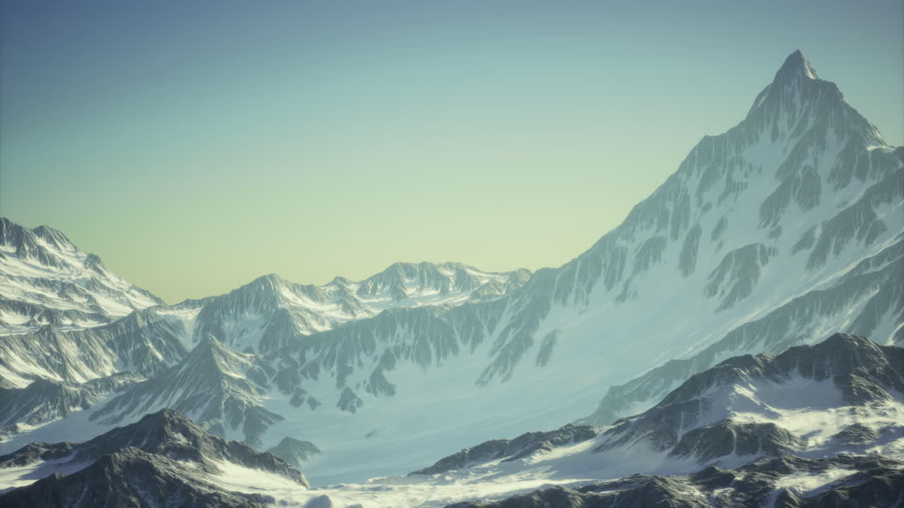 Snow capped mountain range under clear sky at sunrise in a serene landscape