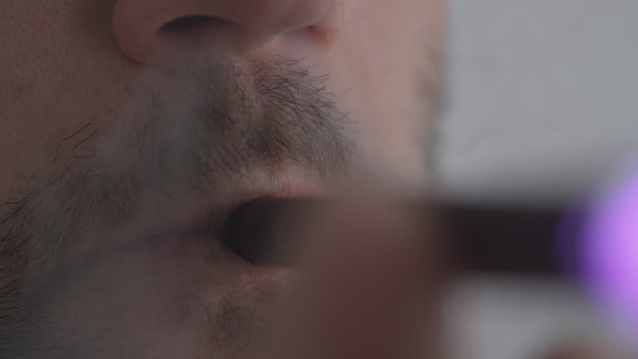 мужчина, использующий vape pen, вдыхающий никотин каннабиса или ароматизированный cbd