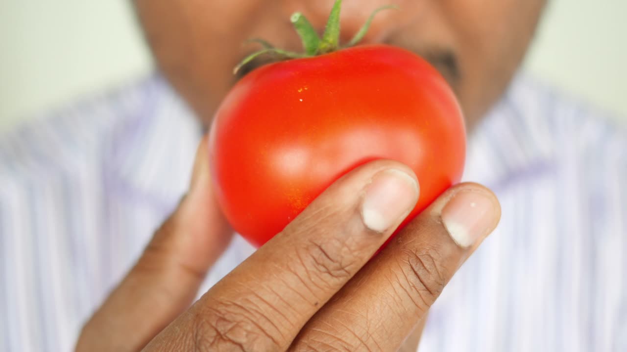 Person smelling a tomato