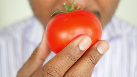 person smelling a tomato
