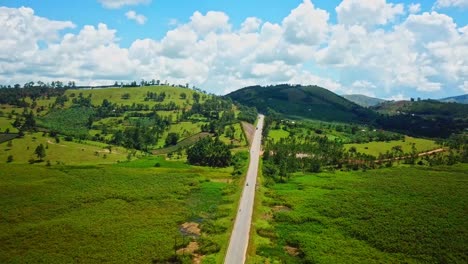 camino rural entre campos verdes en uganda, áfrica oriental - disparo aéreo de avión no tripulado