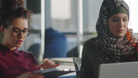 diverse female colleagues discussing documents