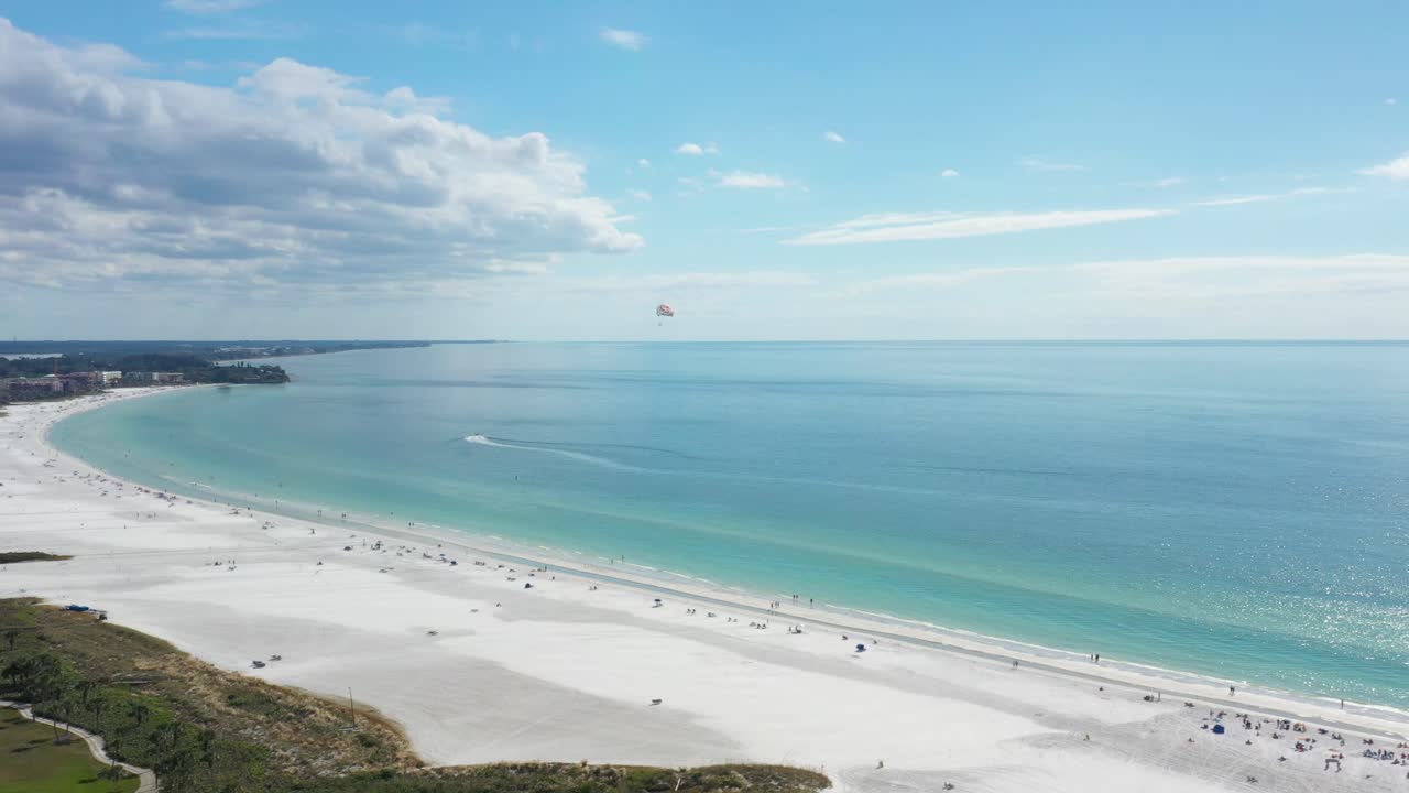 vista aérea de la playa de siesta key con arena blanca y agua turquesa, parapente volando sobre la playa