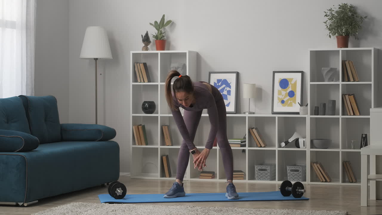 una mujer bonita con cola de caballo está haciendo inclinaciones durante el entrenamiento matutino figura esbelta vestida de moda ropa deportiva delgada mujer deportiva está entrenando en casa mantenerse en forma