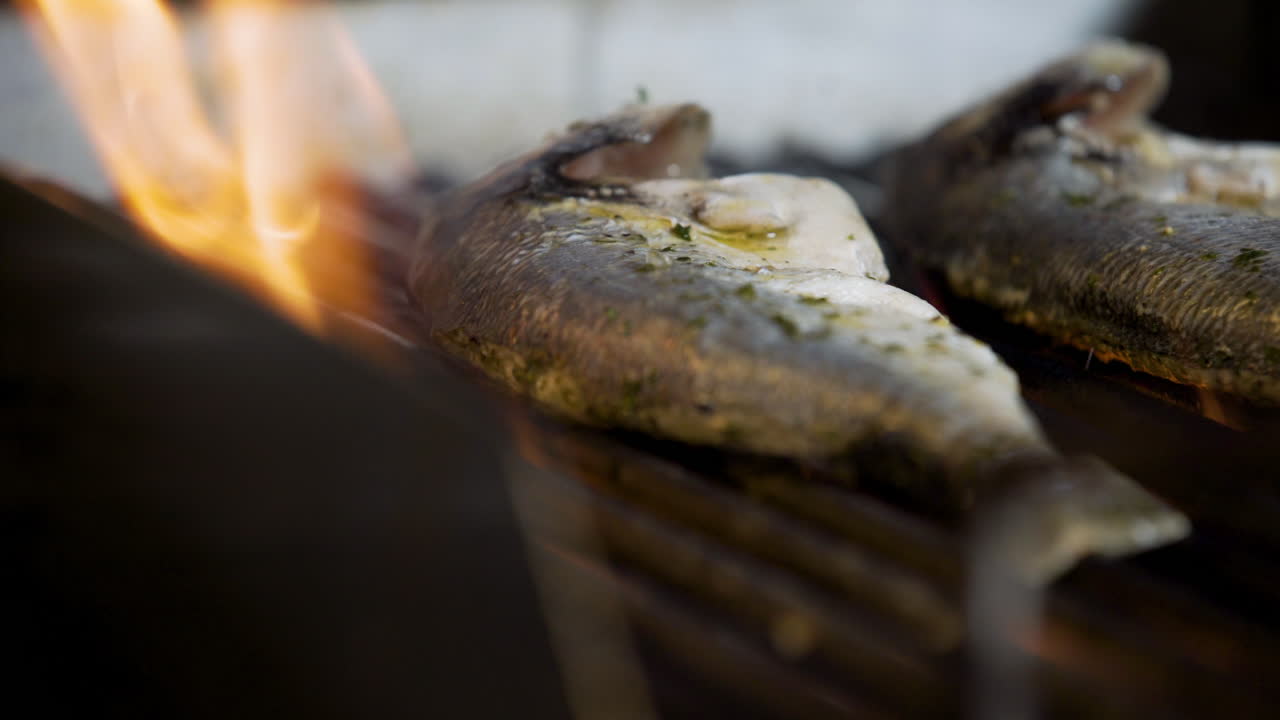 Cuoco che griglia pesce in cucina 1