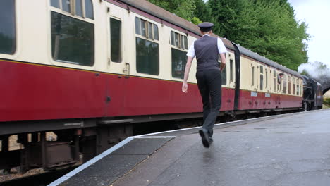 steam train locomotive railway conductor walking along the platform at the station