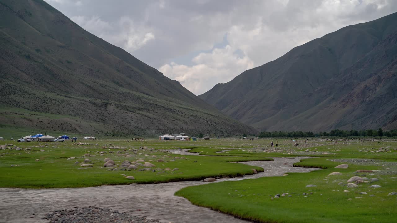 lapso de tiempo de nube de campo mongol con río, montañas, yurtas-gers en el fondo, provincia de uvs