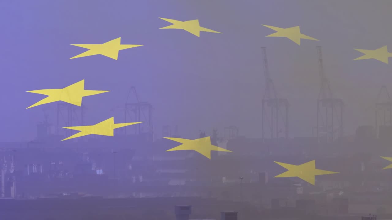 Raffiche di vento che sollevano la bandiera dell'UE, facendo ondeggiare le stelle gialle e scoprendo gru portuali dietro la foschia