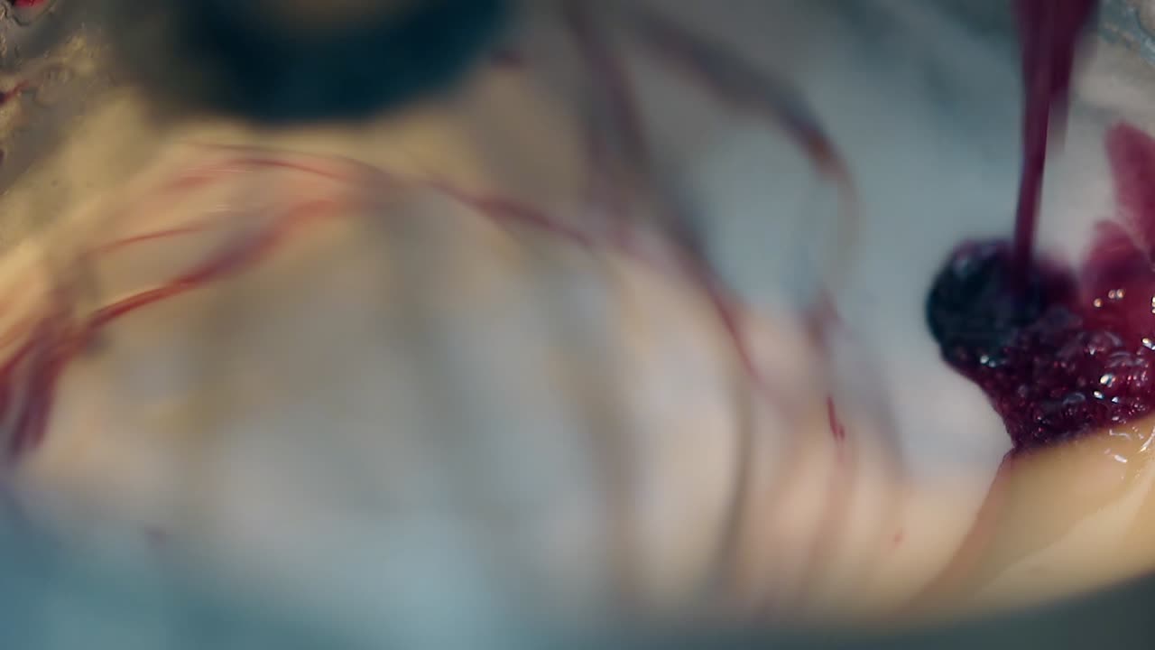 el confitero agrega jarabe a la crema del pastel y mezcla los ingredientes