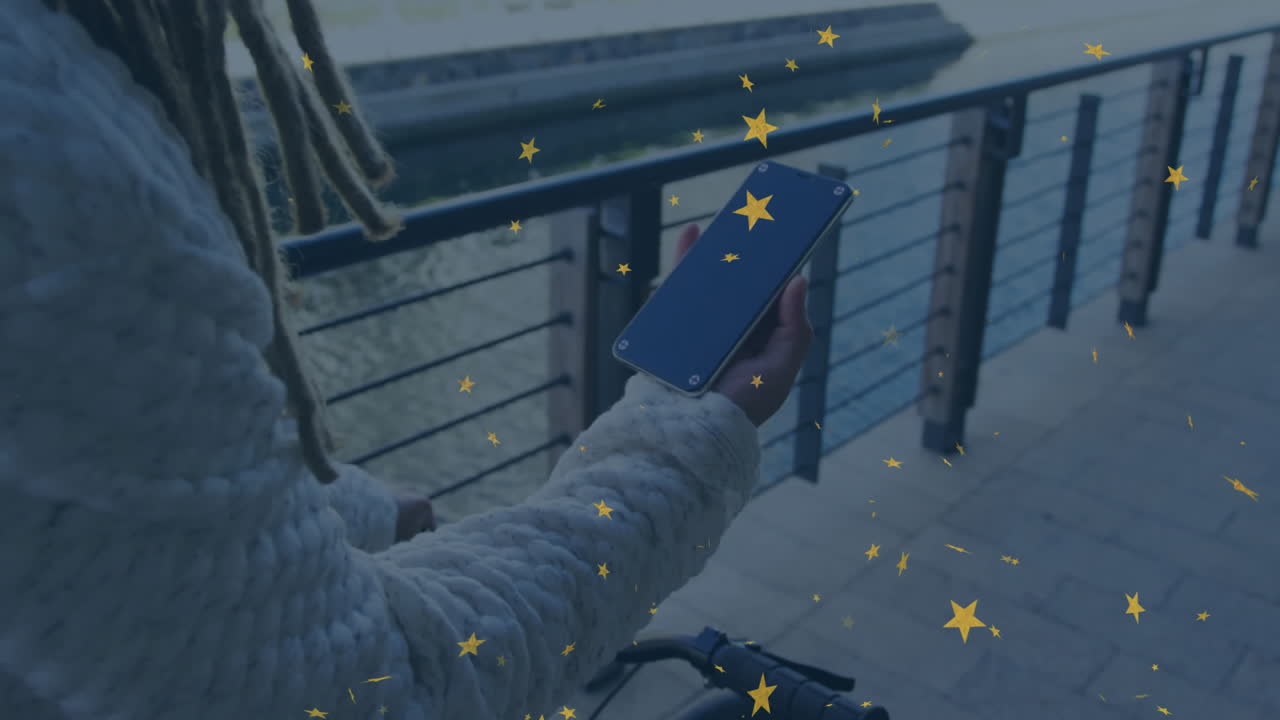 Holding smartphone over bicycle, person viewing star animation overlay outdoors