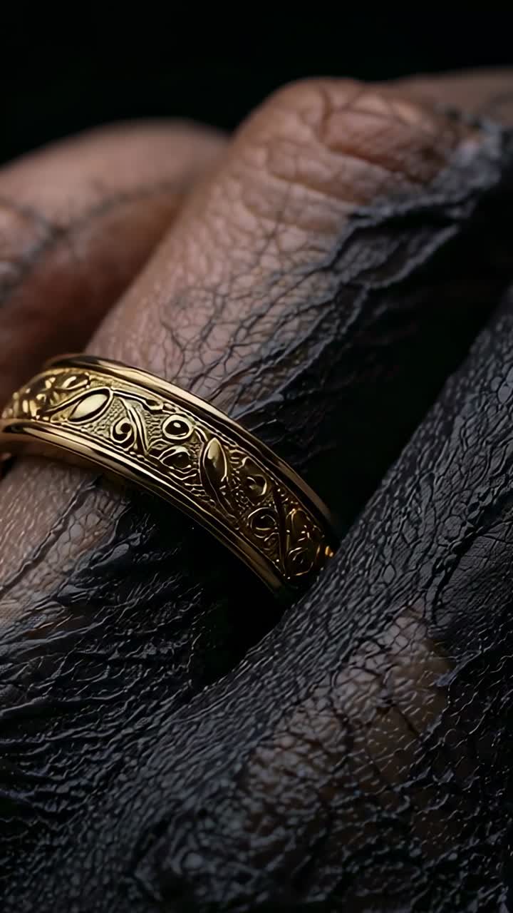 Vertical video: Shifting camera revealing finger wearing ornate gold band in studio showing detail