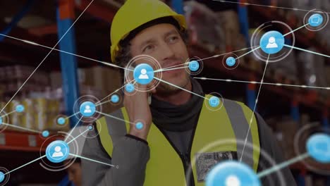 Animation-of-network-of-connections-with-icons-over-caucasian-male-worker-in-warehouse