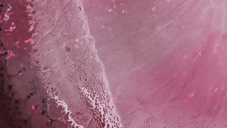 macro shot of soft pink and magenta color ink getting blended together