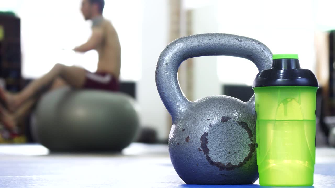 체육관 의 스포츠 장비, 배경 에 피트니스 공 에 운동 하는 남자