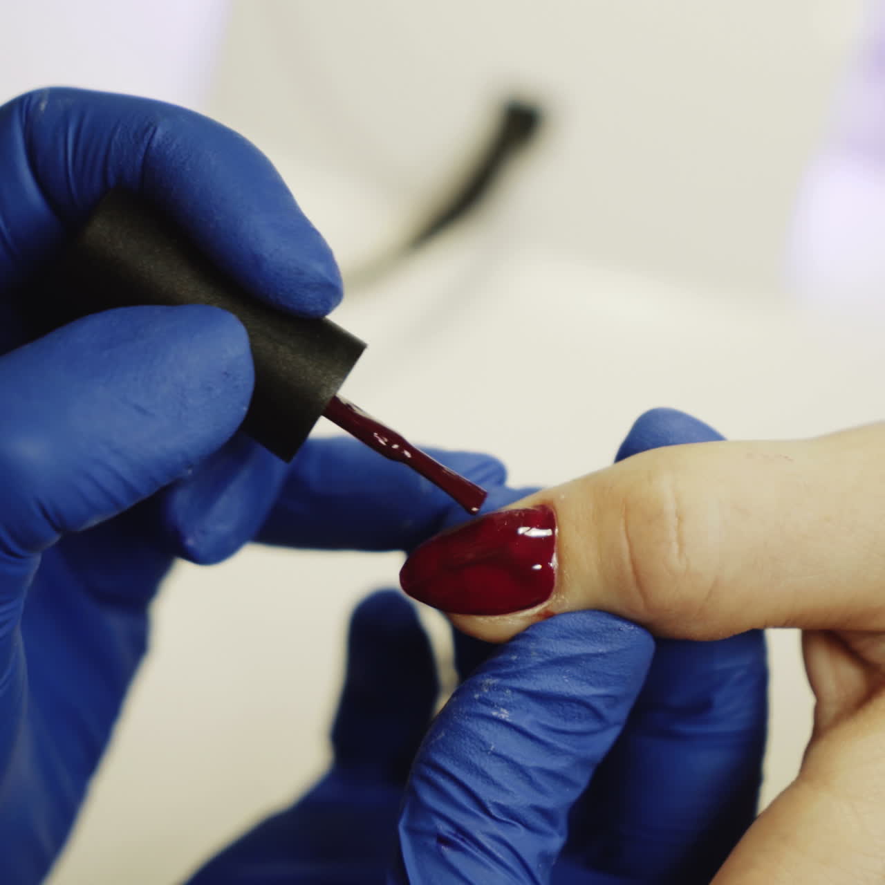 Master of nails paints nails with red lacquer in the salon. Relaxing day at beauty salon. Close-up Square video