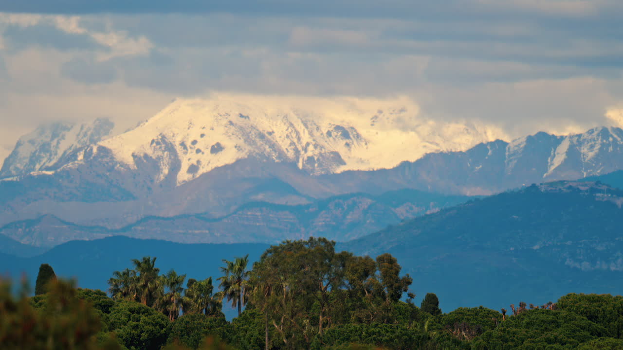 Distant view of the snowed mountains in France on a cloudy day