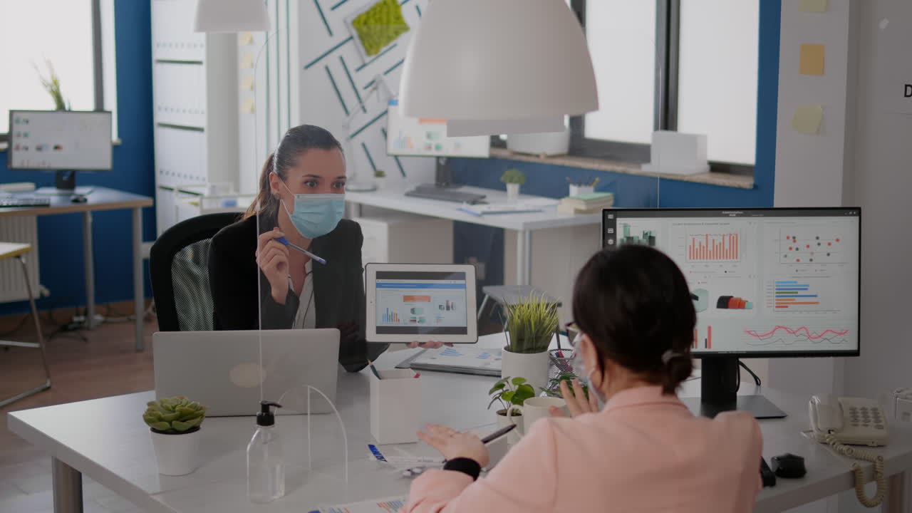 동료 와 함께 통계 를 분석 하는 얼굴 마스크 를 쓴 사업가