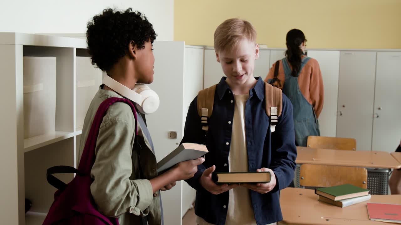 Two students exchanging books in a school classroom