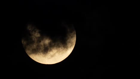 The-full-moon-appears-from-behind-some-inky-black-clouds