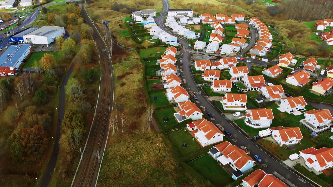 Hyggeligt amerikansk-inspireret boligkvarter omgivet af frodig grøn skov og jernbane på den anden side.