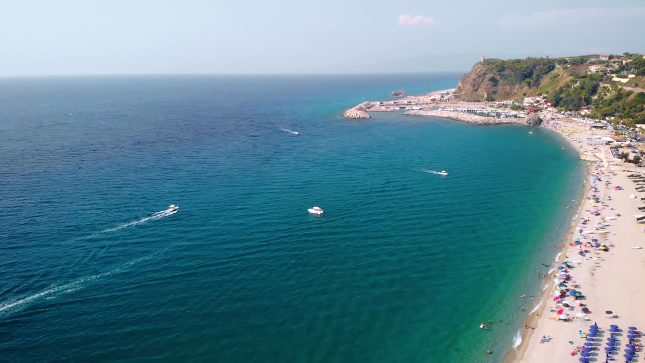 Aerial, drone shot of boats on the coast of Calabria, at the Palmi Beach, on a sunny day, southern Italy