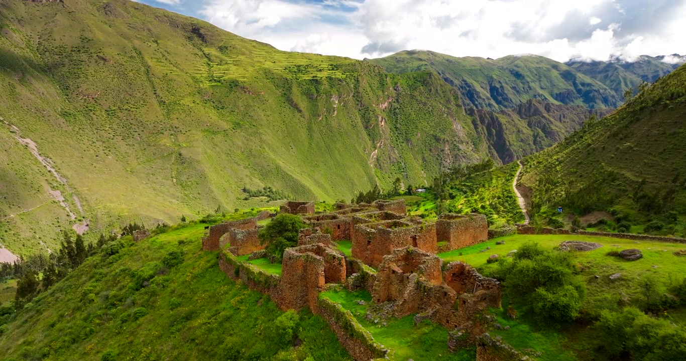 Le antiche rovine Inca di Pumamarka in Perù. Queste storiche strutture in pietra sono immerse su una lussureggiante cresta montuosa verde nel cuore delle Ande, vista aerea cinematografica con carrello.