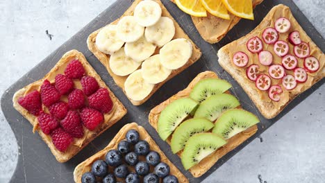 Wholegrain-bread-slices-with-peanut-butter-and-various-fruits