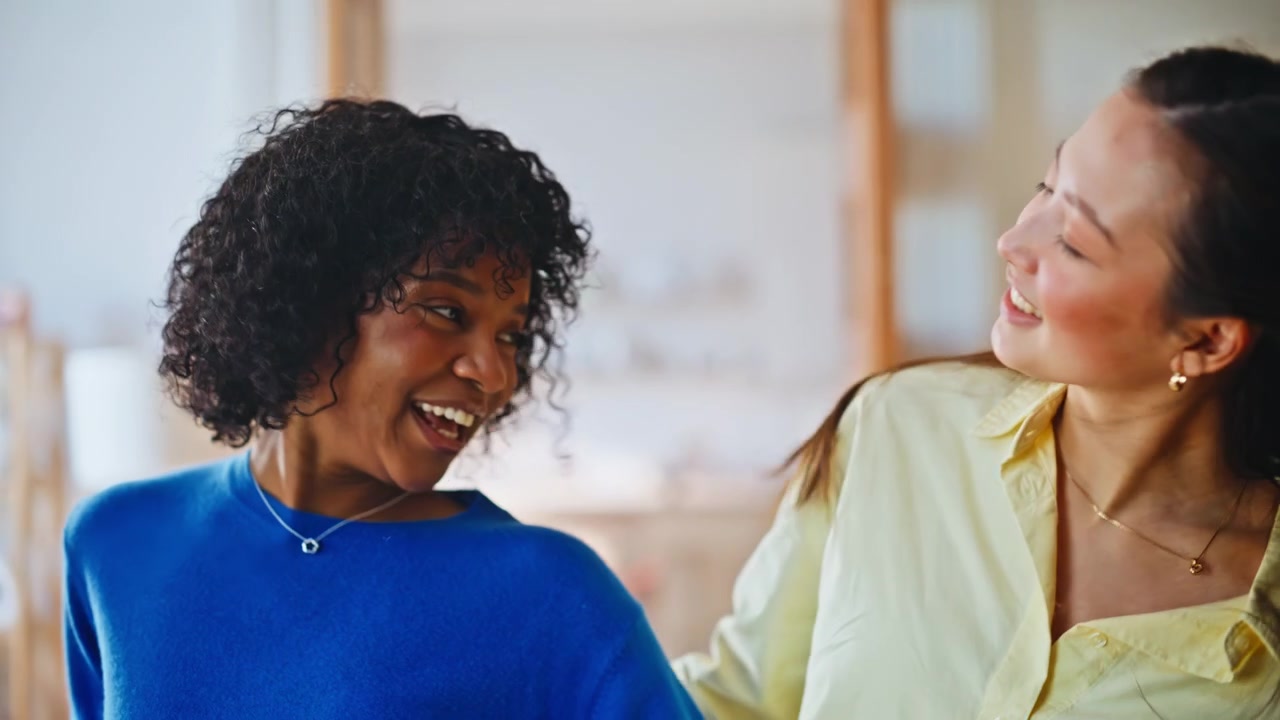 Girlfriends laughing bonding home. Cheerful roommates having fun closeup.