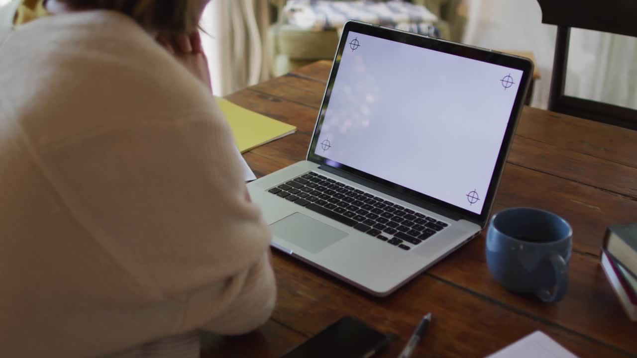 Asian woman sitting at table and making video call using laptop with copy space