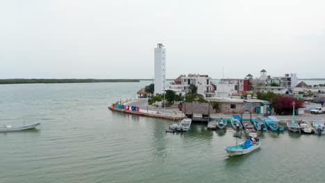 Flug-Um-Die-Küste-In-Einer-Kleinen-Stadt.-Am-Ufer-Festgemachte-Boote-Und-Bunte-Ortsbeschriftung.-Rio-Lagartos,-Mexiko.