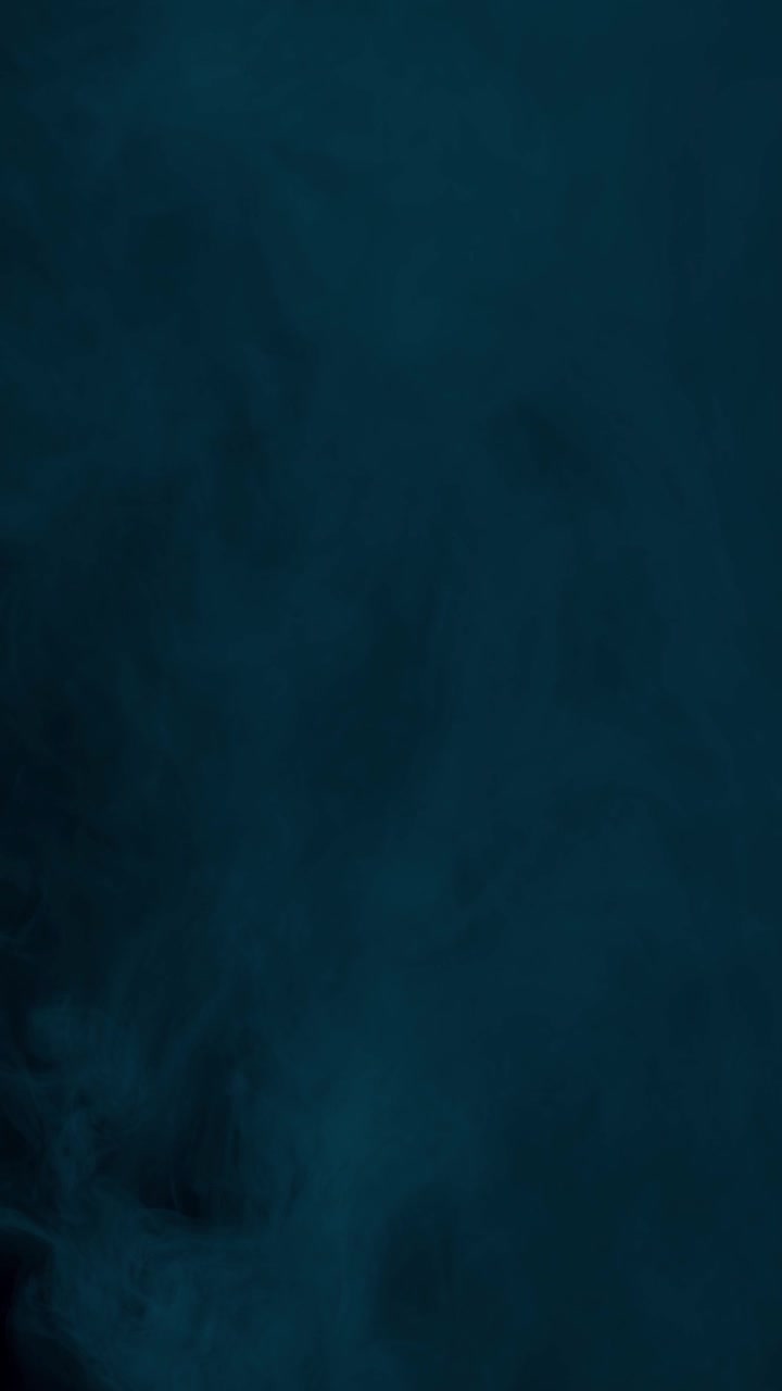 Dark and moody cyan fog fills screen, creating mysterious and cold atmosphere on black background, vertical format