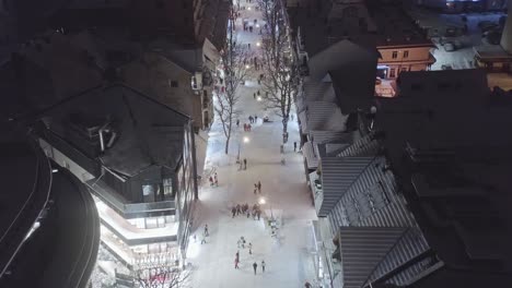 aerial view over main street of zakopane in krupowki neighborhood at night with people walking