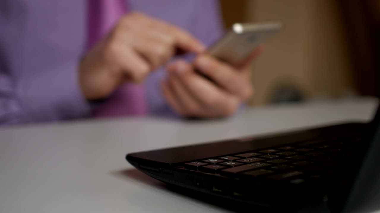 un uomo d'affari con una camicia viola e una cravatta usa uno smartphone. legge notizie, fa shopping online, guarda i social network.