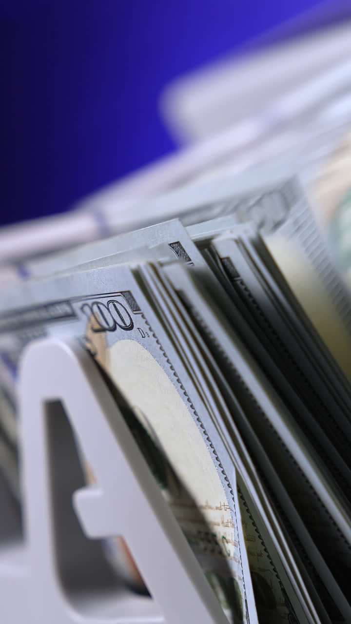 Currency counting machine counts 100 dollar bills. Cash bill counter money machine. Automatic mechanism for bank financial operations. Finance concept. Close-up. Vertical video