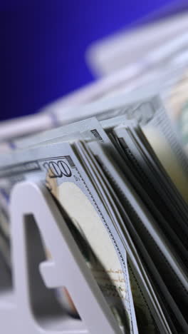 currency counting machine counts 100 dollar bills. cash bill counter money machine. automatic mechanism for bank financial operations. finance concept. close-up. vertical video