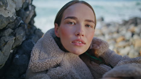 fashion lady posing beach in coat portrait. attractive traveler at ocean shore