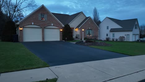 mail box at street in front of american house with double garage at dusk
