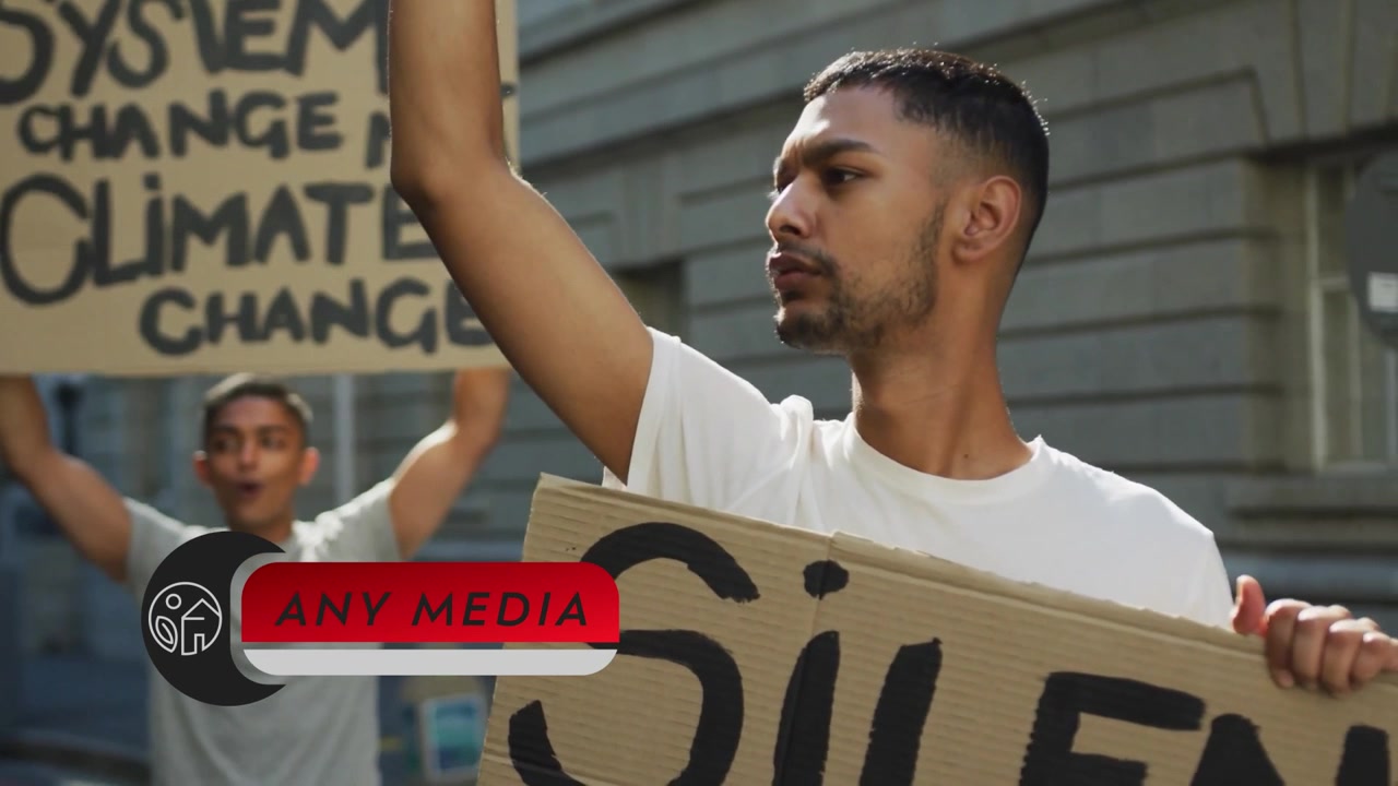 Diverse Group of Protesters Holding Signs and Raising Fists in Demonstration