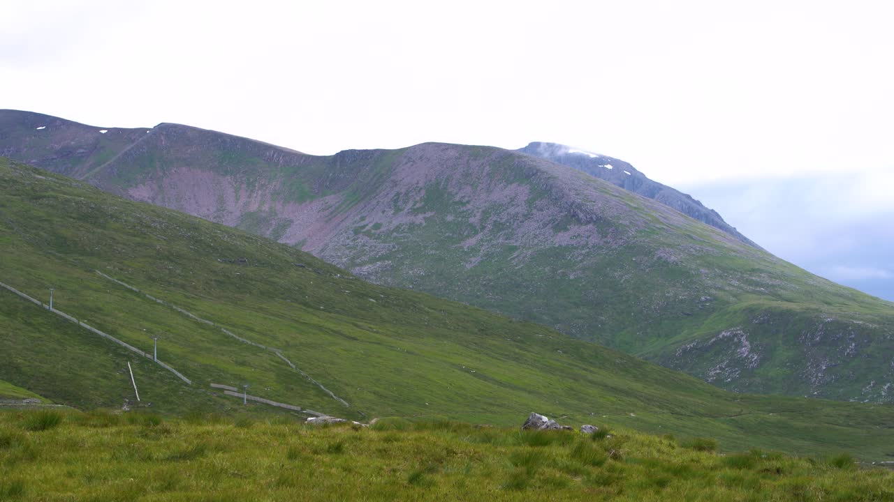 잔잔한 바람 없는 여름날 스코틀랜드의 언덕이 많은 풍경 위로 천천히 움직이는 하얀 낮은 구름